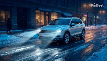 Кросовер їде зимовою міською дорогою у сутінках — видимість на дорозі та онлайн-страхування FinBest 2026